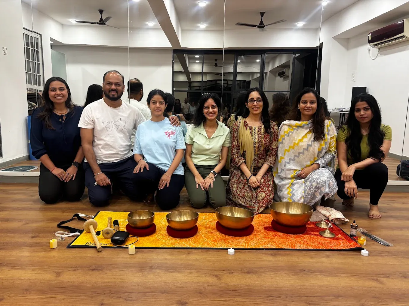 Group with singing bowls in the mirrored, wood-floored studio at Safemind Studio, Baner, Pune